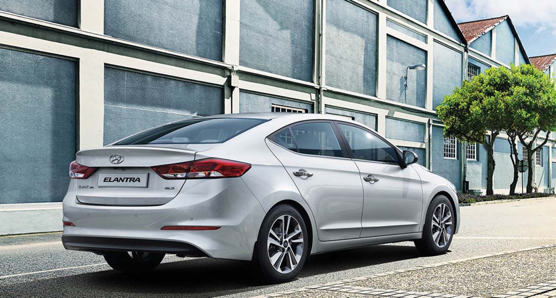 Right side rear view of silver Elantra parked in front of the building