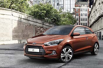 A brown i20 coupe on the street.