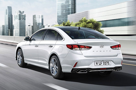 Left side rear view of white sonata driving on the road