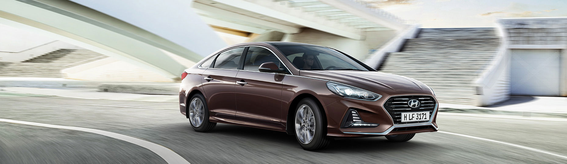 Right side front view of brown sonata driving on the road