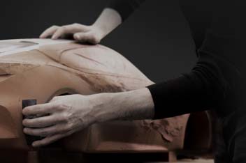 Closer view of hands polishing a clay model.